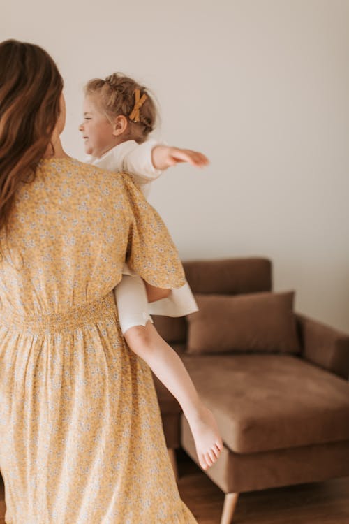 Mother Carrying Her Happy Daughter