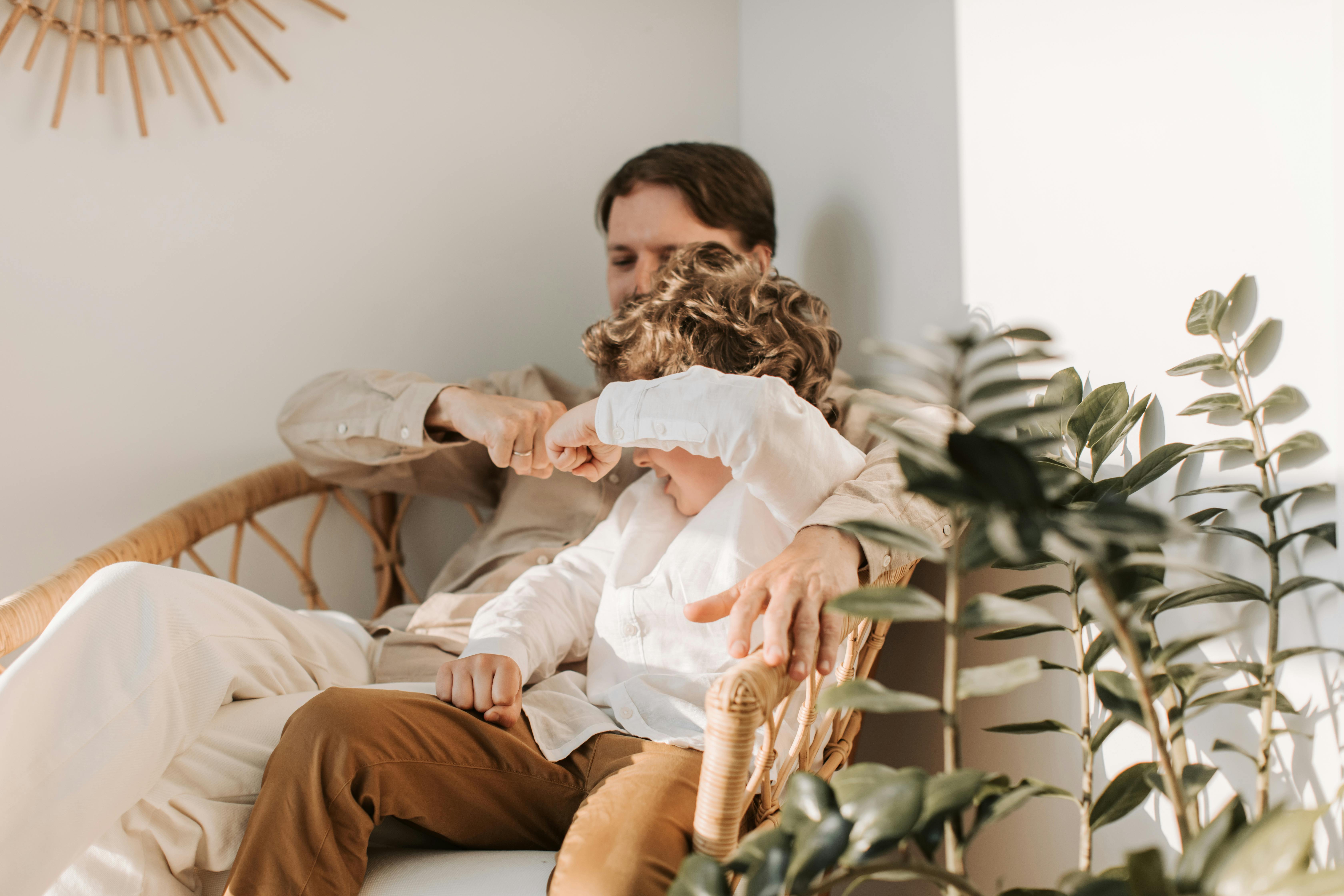 Father Sitting with his Son and Fist Bumping · Free Stock Photo