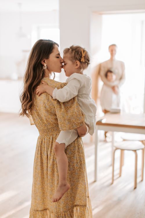 Free A loving embrace between a mother and her daughter in a sunlit room. Stock Photo