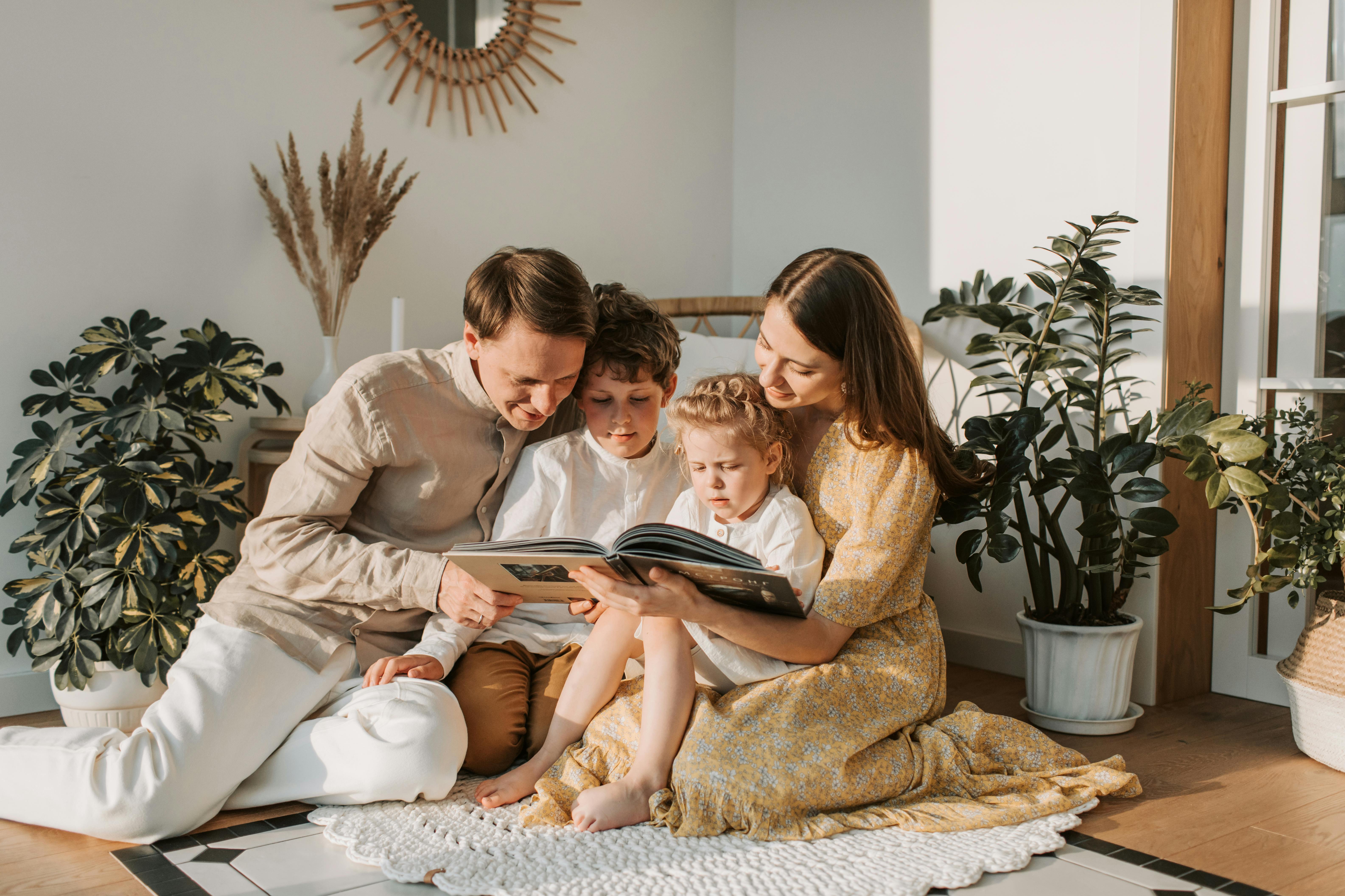 a family sitting on floor reading a book