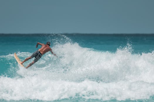 一位热爱冒险的冲浪者在夏威夷蔚蓝的天空下乘风破浪，展现出动态与激情