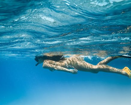 一名女子在夏威夷清澈的海水中浮潜，体验水下冒险