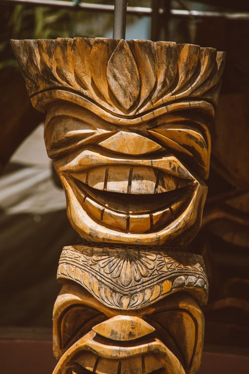 Free Close-up of a traditional tiki sculpture with intricate carvings and a smiling face in Hawaii. Stock Photo