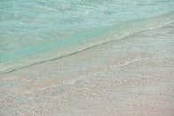 在夏威夷宁静的沙滩上，柔和的绿松石波浪的特写