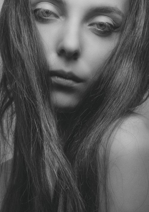 Free A striking black and white portrait of a woman with flowing hair, evoking a moody and artistic tone. Stock Photo