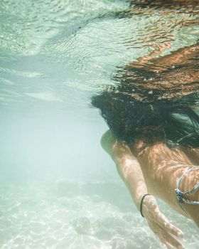 在夏威夷清澈的海水中，一位女士正在享受水下游泳