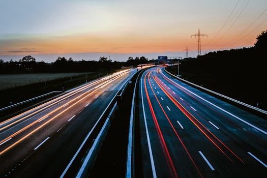 Stunning long exposure of light trails on a highway during dusk, showcasing movement and serene skies.