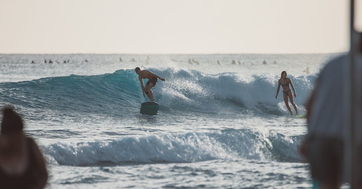 Photo by Jess Loiterton Dynamic scene of surfers catching waves in Honolulu with a clear blue ocean backdrop.
