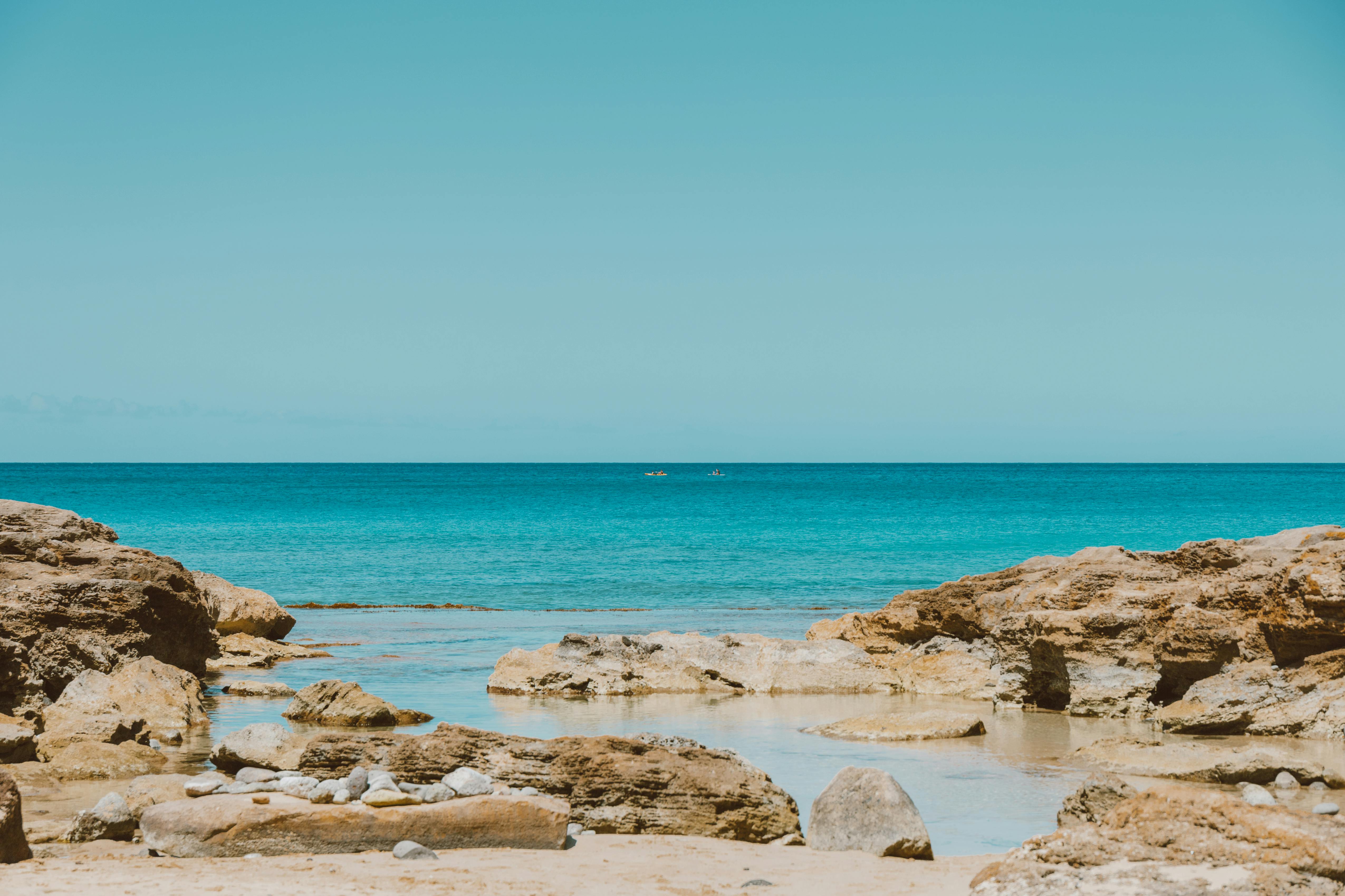 宁静的海滩场景与蓝色的海洋和岩石海岸，完美的放松