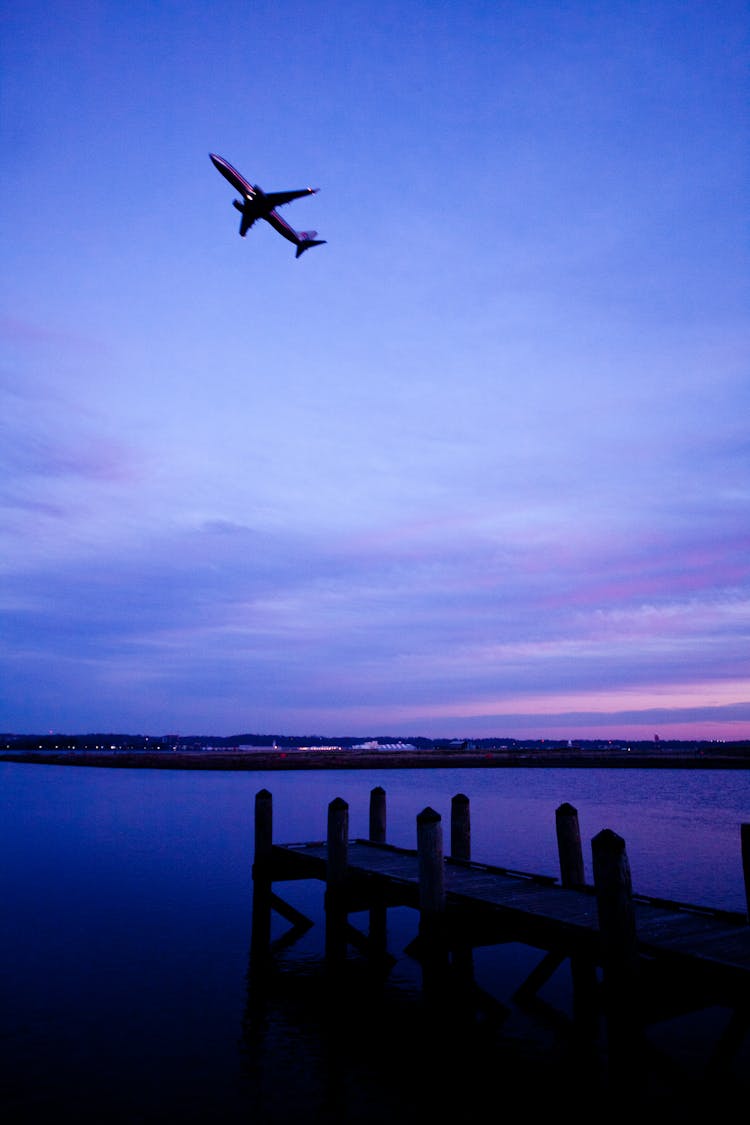 An Airplane Flying Under Blue Sky