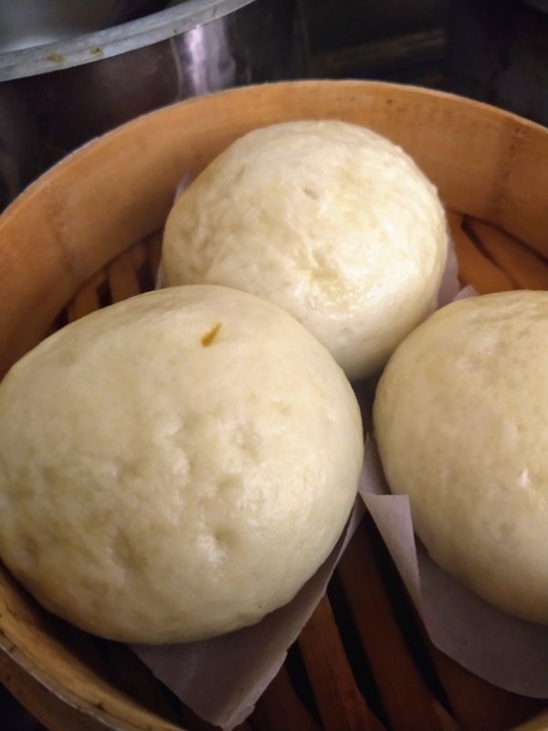 一位留学生手持护照和录取通知书,站在机场航站楼前,背景是飞机跑道和蓝天。