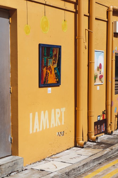 Free Colorful street art on a yellow building in Singapore, featuring vibrant paintings and urban creativity. Stock Photo