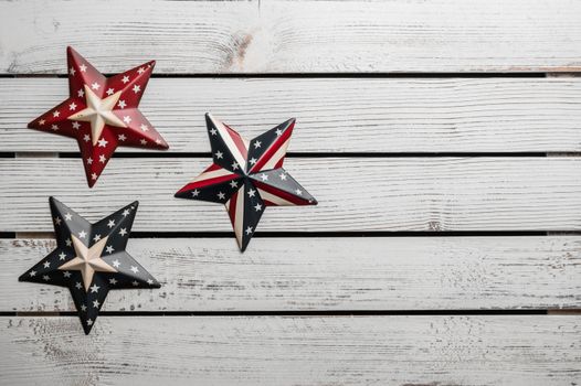 From above of various star shaped badges with pattern of United States flag placed on white wooden table