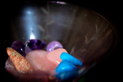 Free A close-up shot of vibrant gemstones in a glass bowl under a dark background. Stock Photo