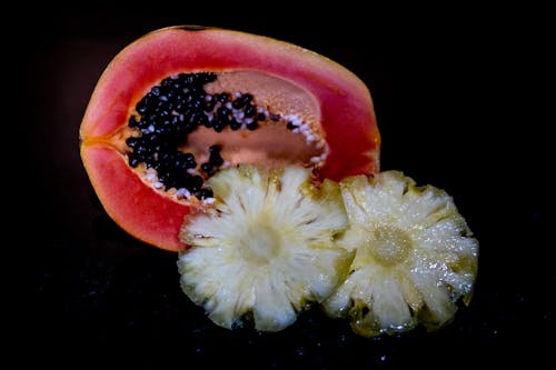 Close-Up Photo of a Sliced Pineapple and Papaya Fruit