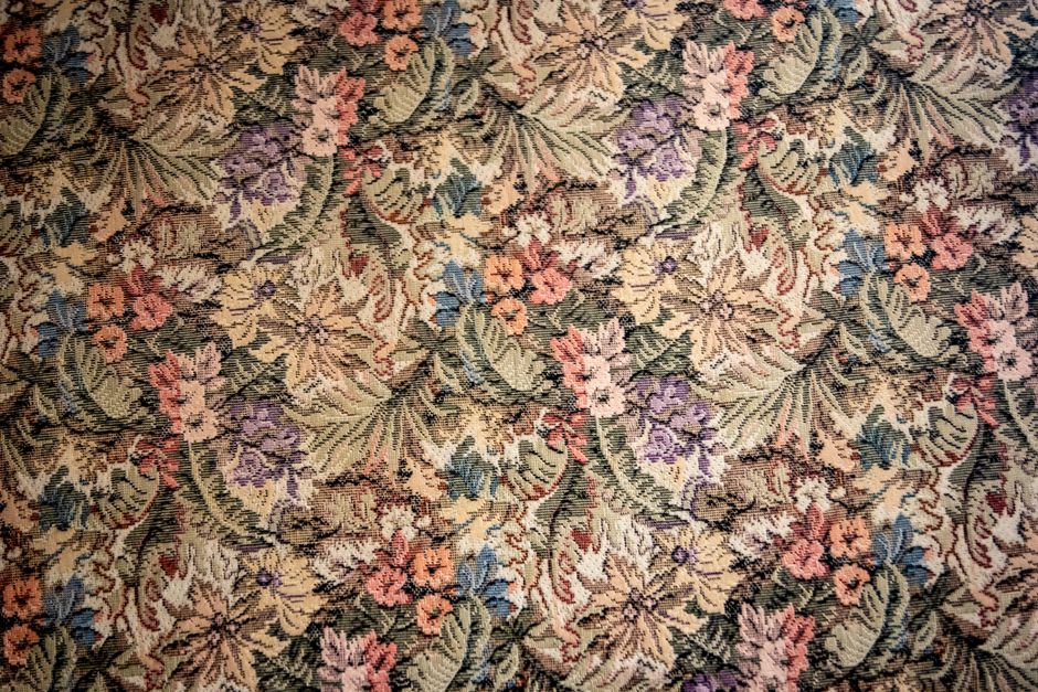 Intricate floral tapestry textile featuring a vintage design with colorful flowers and leaves.