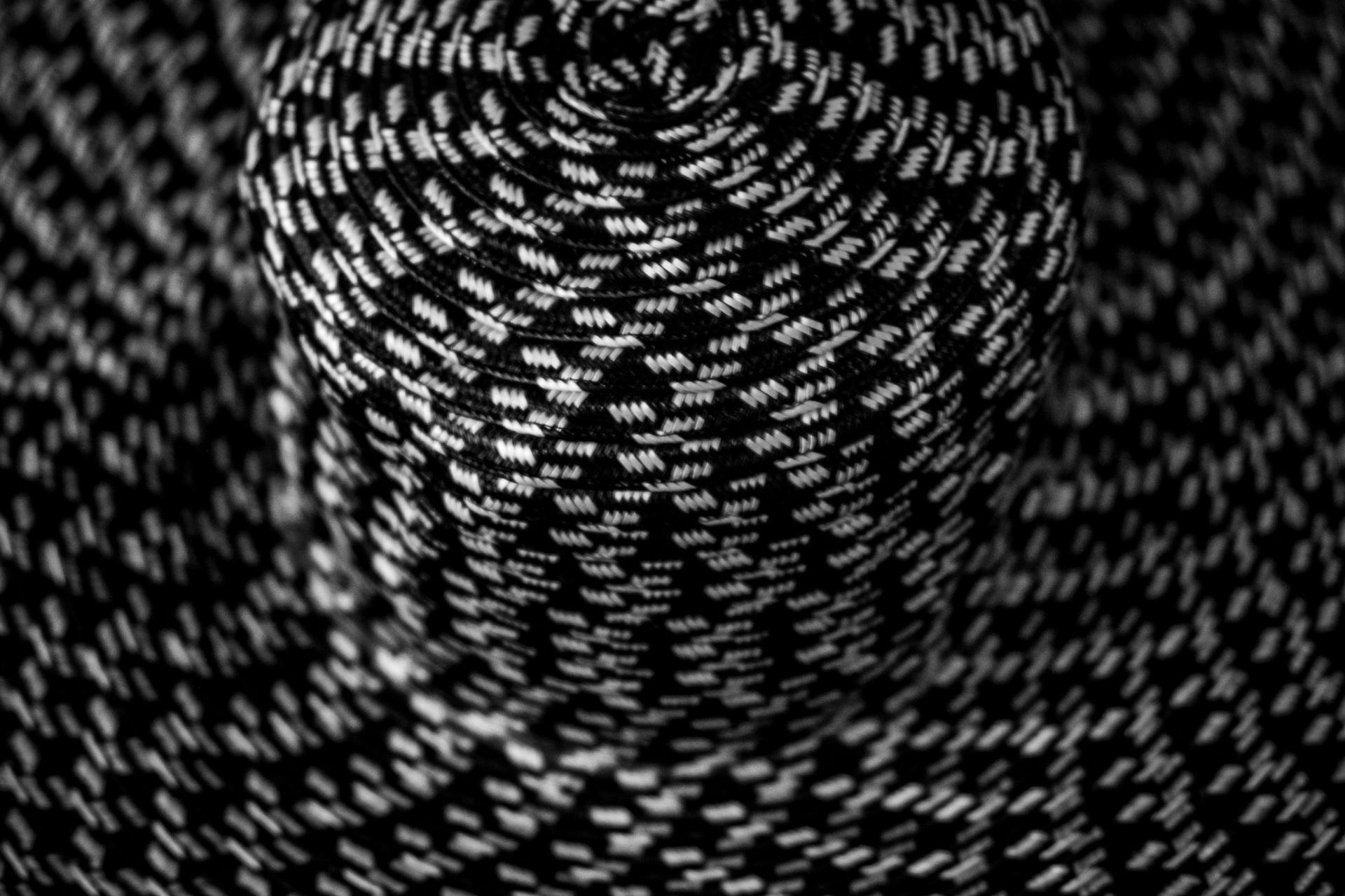 A detailed close-up of a black and white woven paracord pattern, emphasizing texture and contrast.