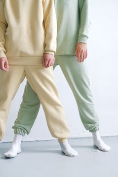 A minimalist fashion photo showcasing neutral-toned sweatpants in a studio setting.