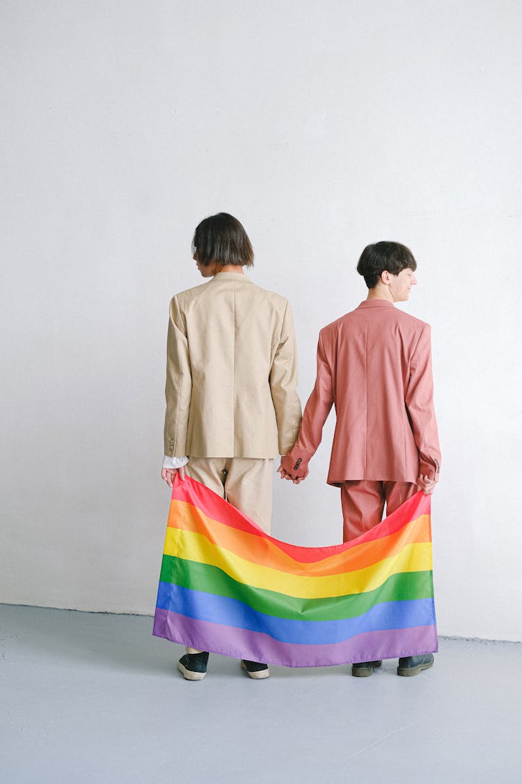 Men In Suits Holding A Gay Pride Flag