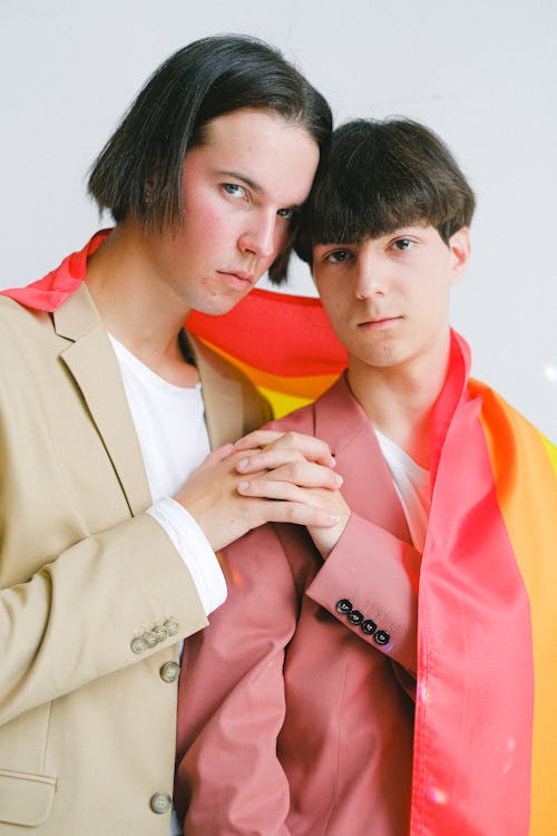 Two Men With a Gay Pride Flag Holding Hands