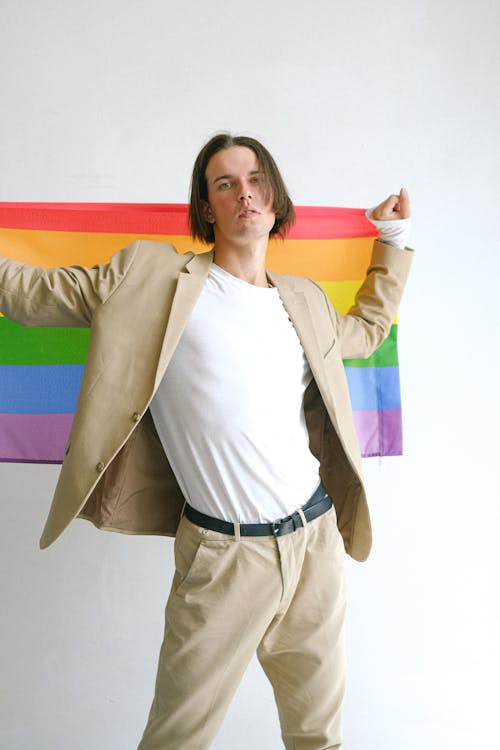 Man In Beige Suit Holding a Gay Pride Flag