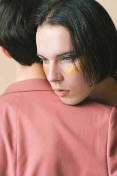 Close-up portrait of two fashion models in a pink suit, showcasing intimacy and style.