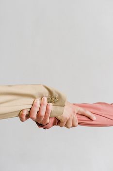 两只穿着正式服装的手互相抓住，象征着团结和支持