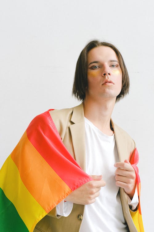 Man With Makeup Holding a Gay Pride Flag