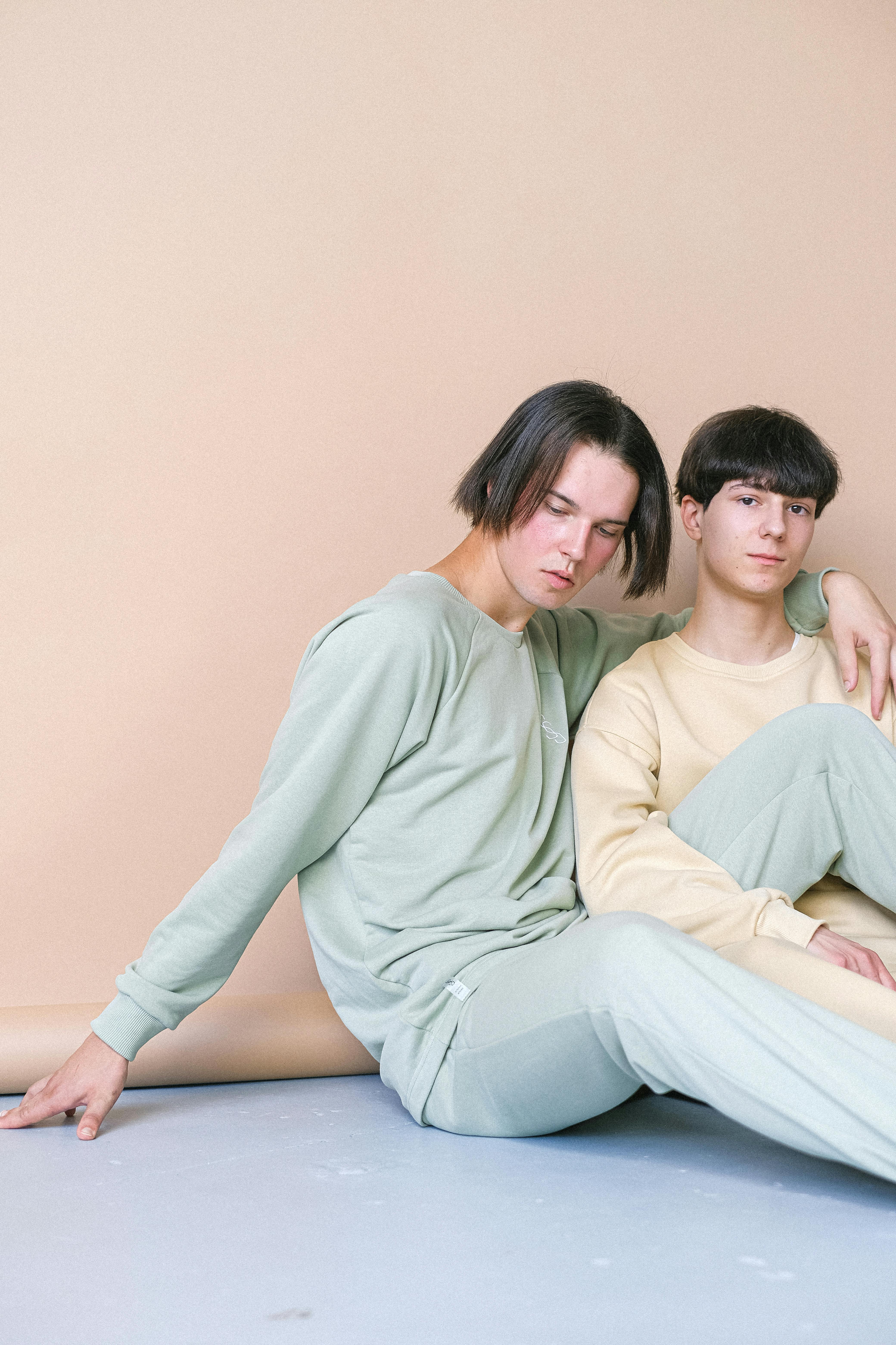 man in green sweater and green pants sitting beside a man in yellow long sleeve shirt