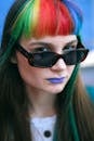 一位彩虹头发、戴着太阳镜的女人肖像充满活力，散发着自信
