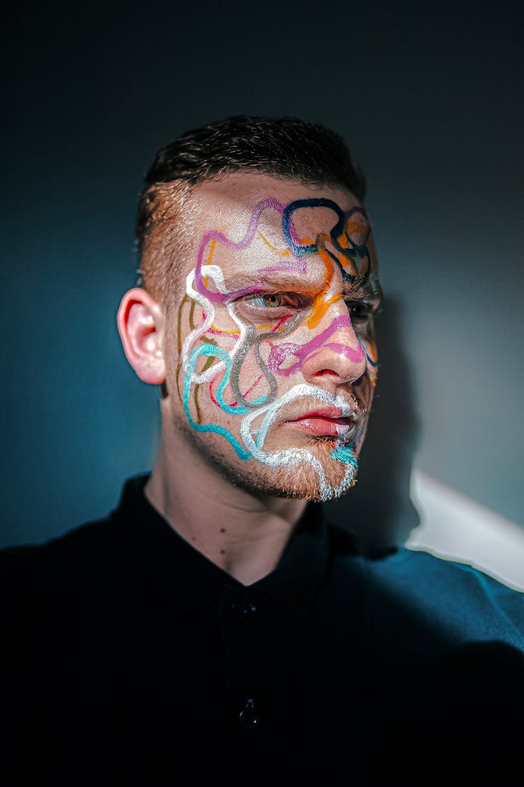 Man With Painted Face Near Blue Wall