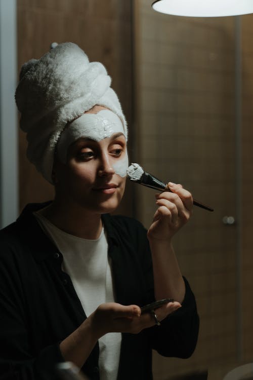 シルバーと黒のヘアブラシを保持している黒のシャツの女性