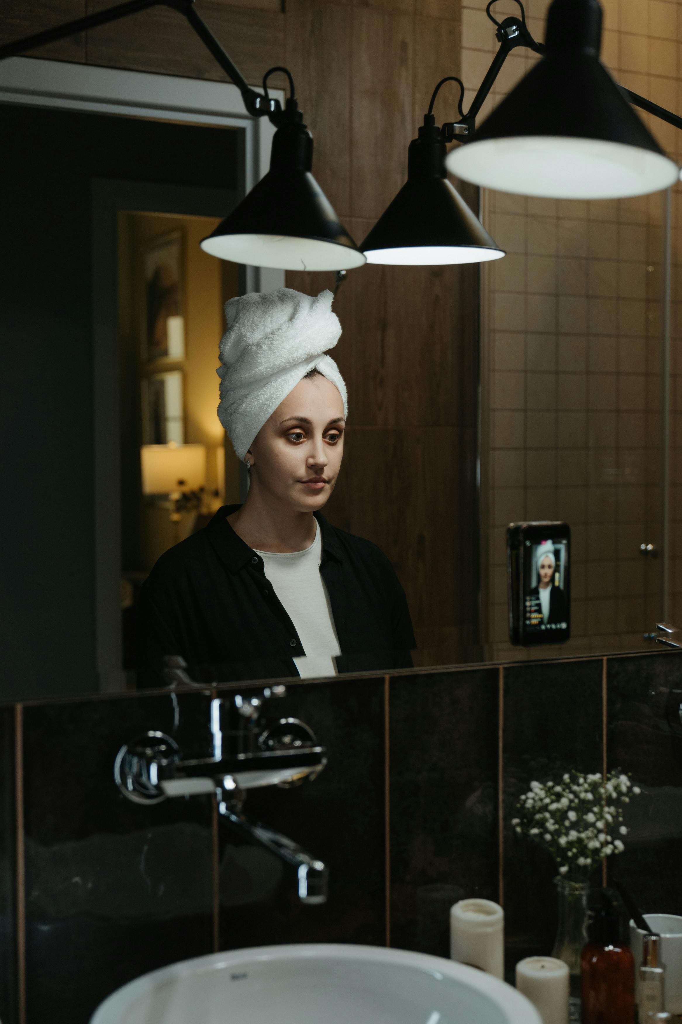 woman in black shirt standing near stainless steel faucet