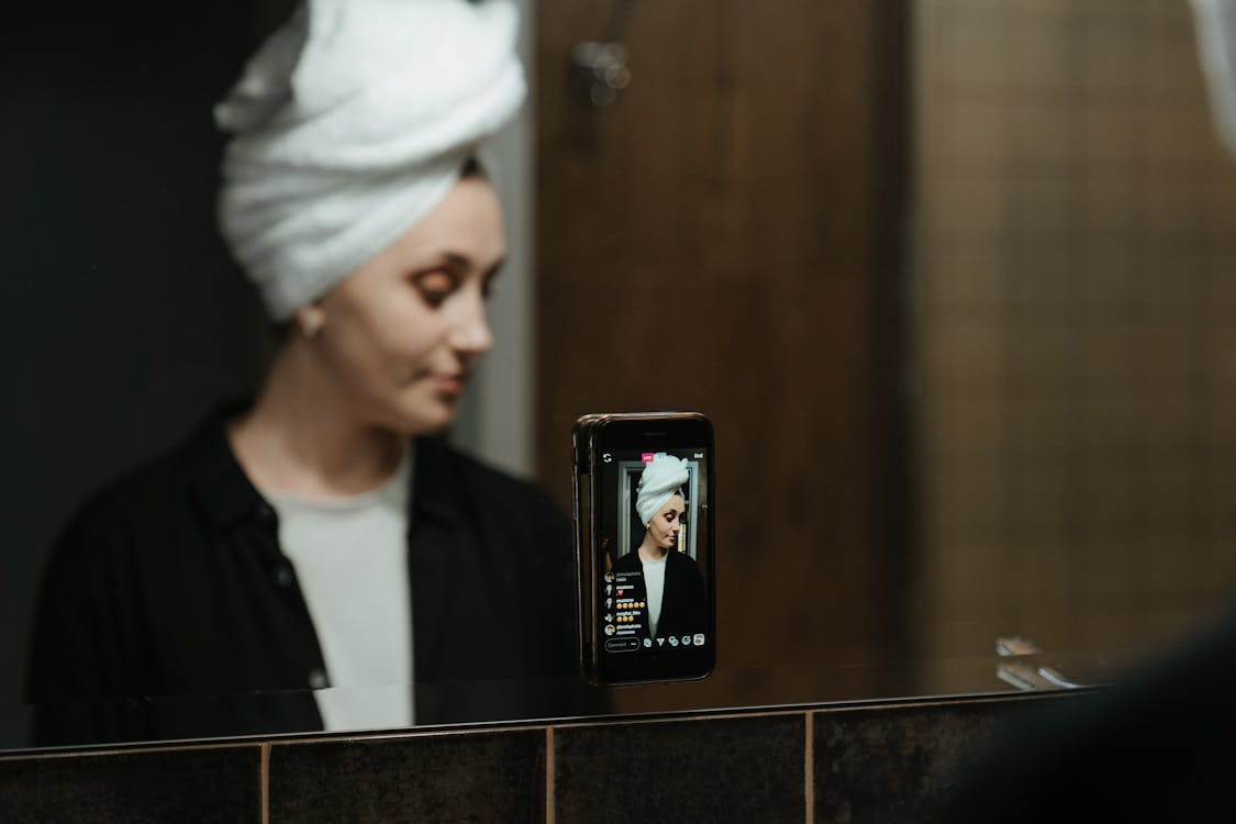 Man in White Knit Cap Holding Black Smartphone