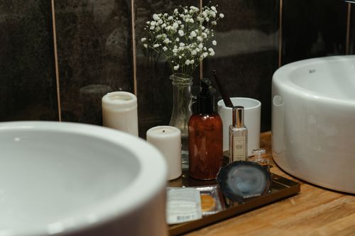 Free A stylish arrangement of skincare products and candles in a modern bathroom setting, perfect for self-care ambiance. Stock Photo
