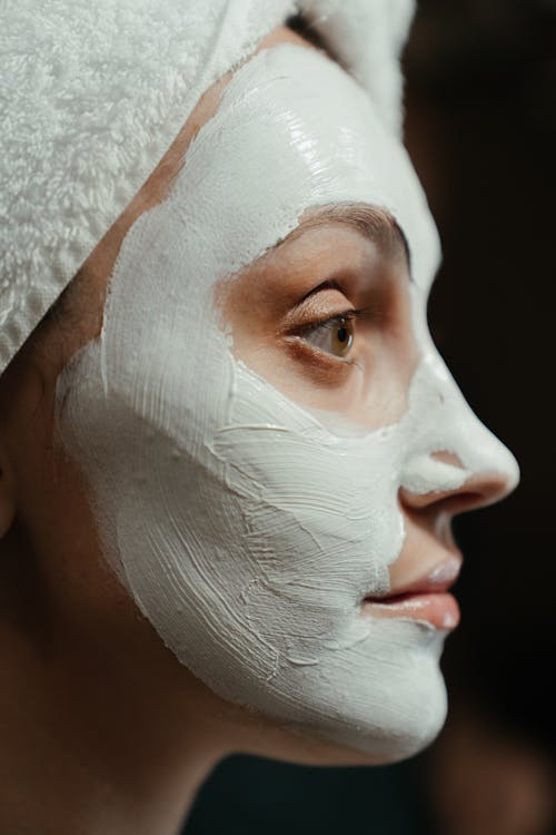 白いフェイスマスクを持つ女性