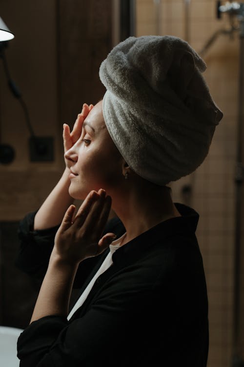 Woman in Black Jacket Covering Her Face With Gray Towel