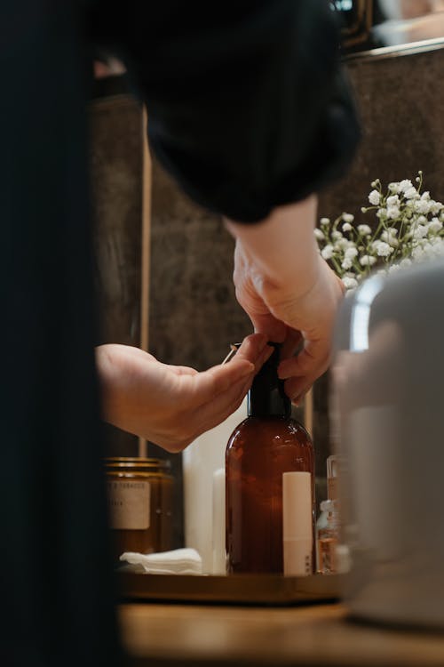 Personne Tenant Une Bouteille En Verre Brun