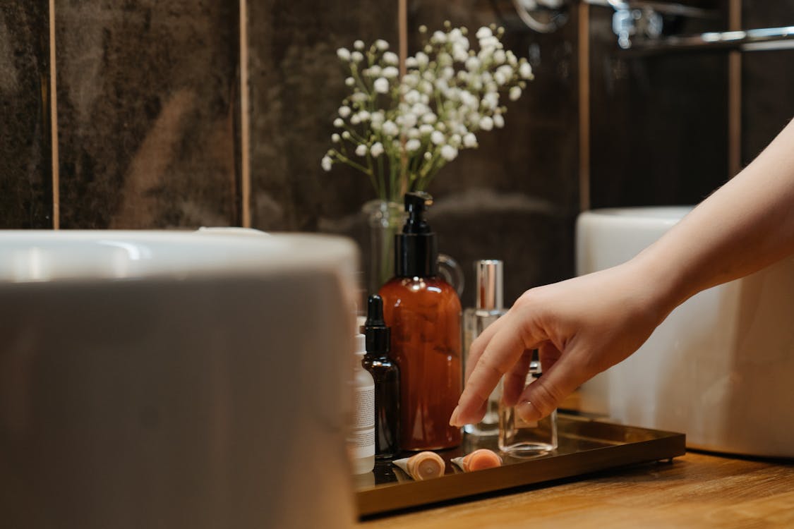 Free Person Holding Clear Glass Bottle With Brown Liquid Stock Photo