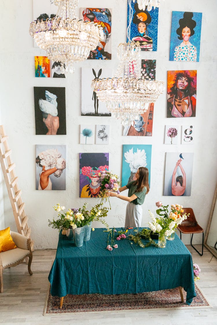 Woman Arranging Flowers On Vases On A Table