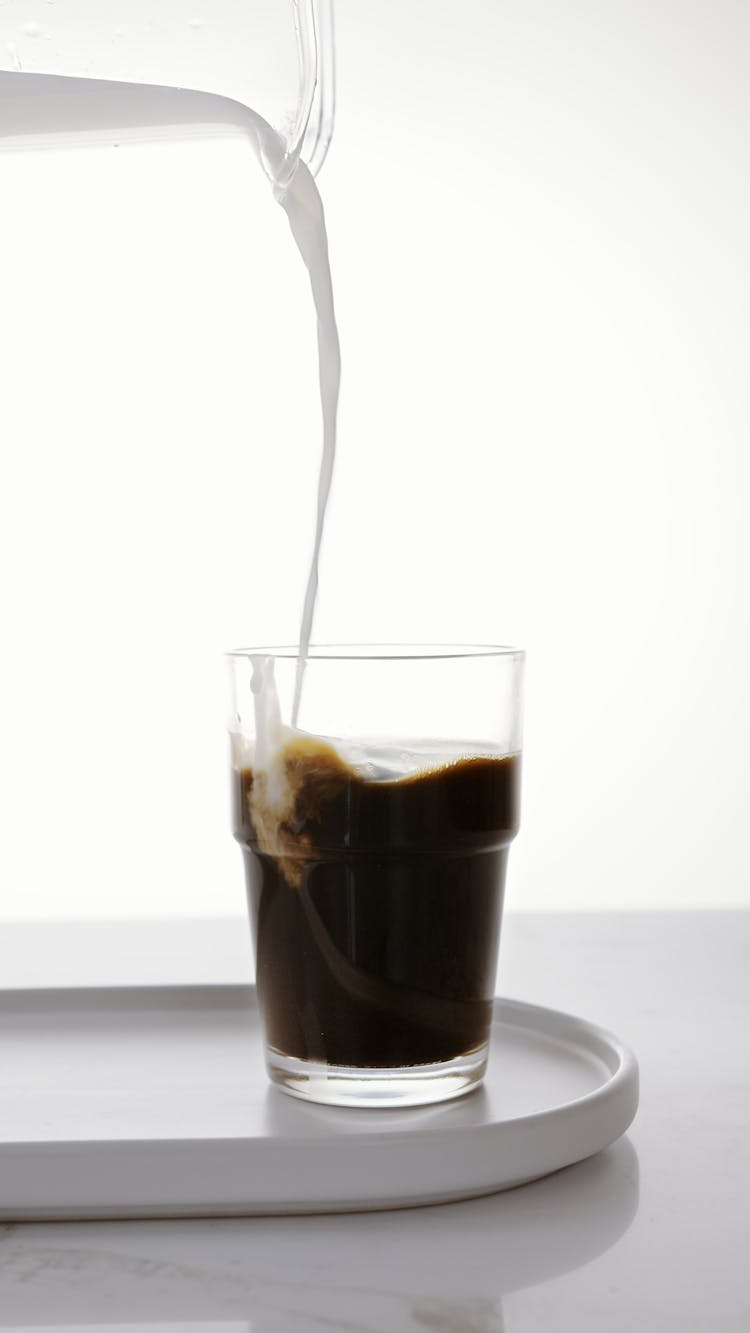 A Pouring Milk On Coffee