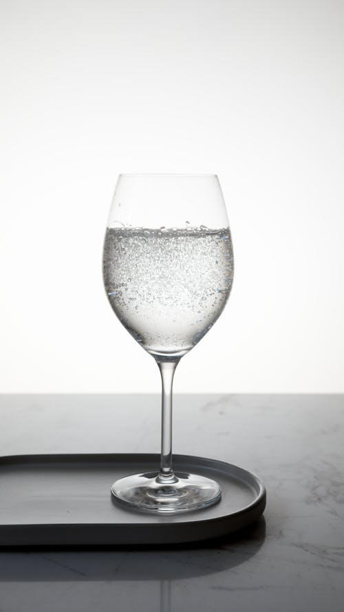 Free Clear Wine Glass with Liquid on Marble Top Stock Photo