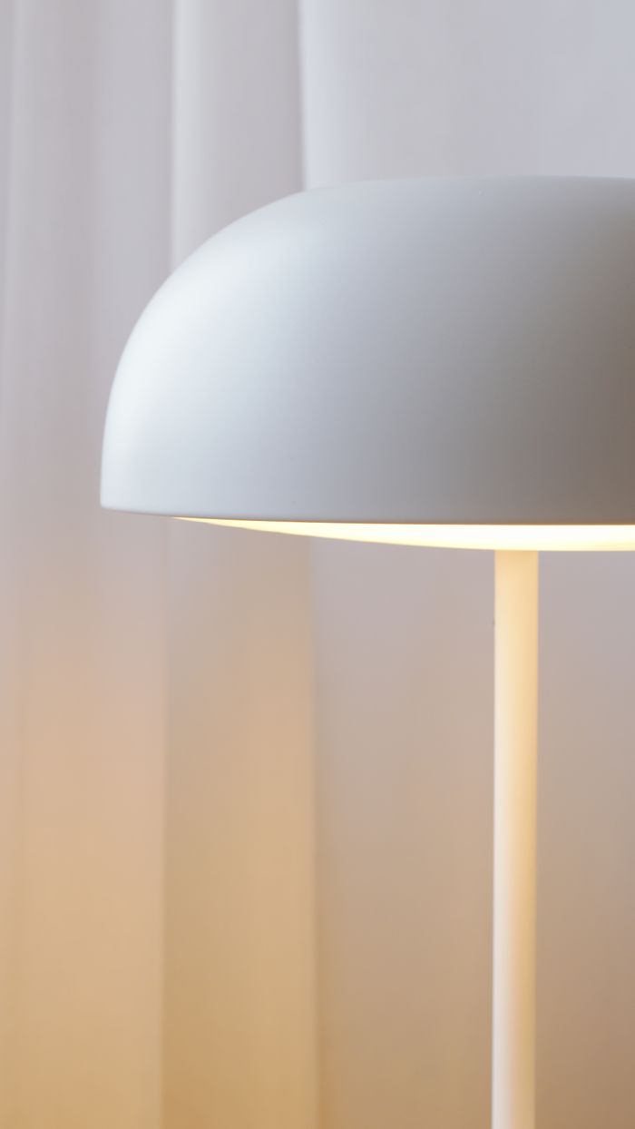 Minimalist dome table lamp glowing against a curtain — photo by Artem Podrez on Pexels
