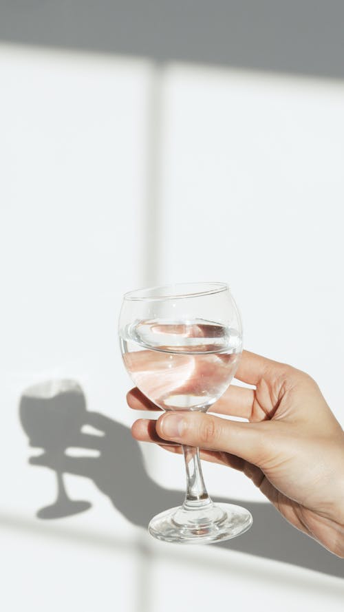 Free Person Holding Clear Wine Glass with Water Stock Photo