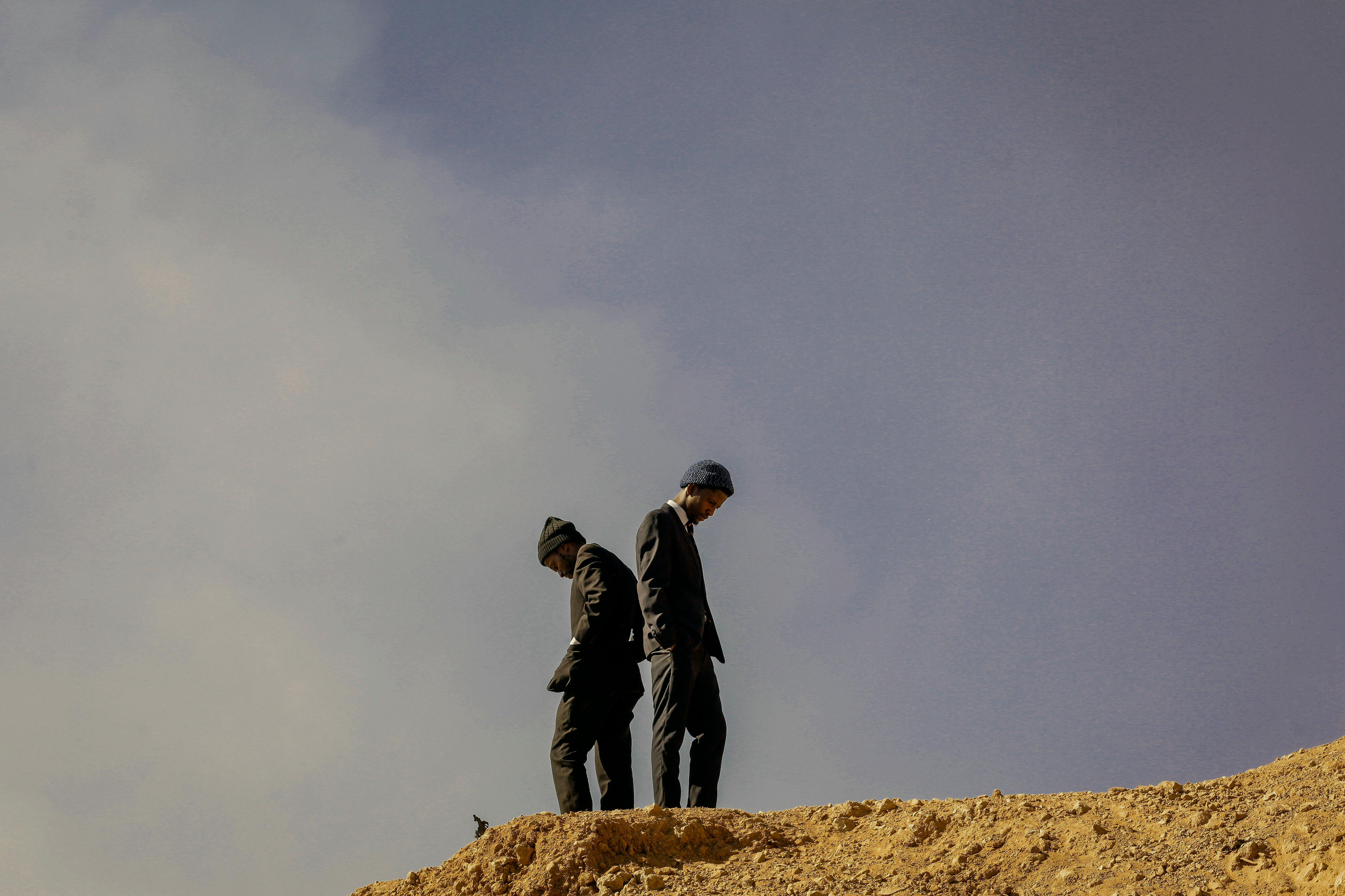 black men standing on top of hill