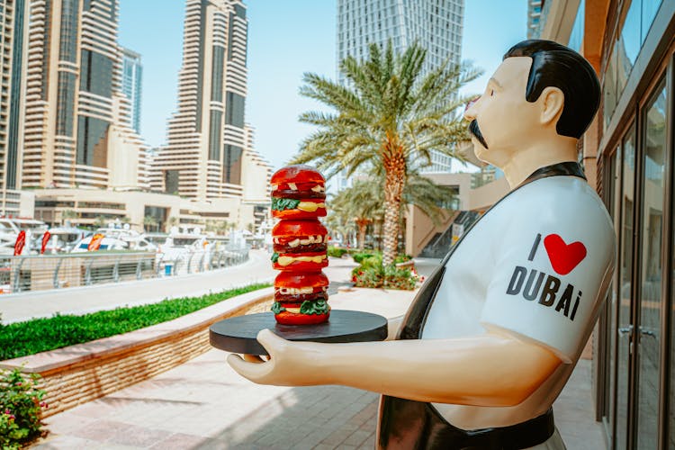 Figurine Statue Of A Man Holding Burgers On Tray