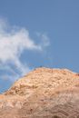 Person Standing on Brown Rock Formation Under Blue Sky