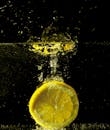 特写镜头捕捉到柠檬片在水中溅起水花，色彩鲜艳，动作生动