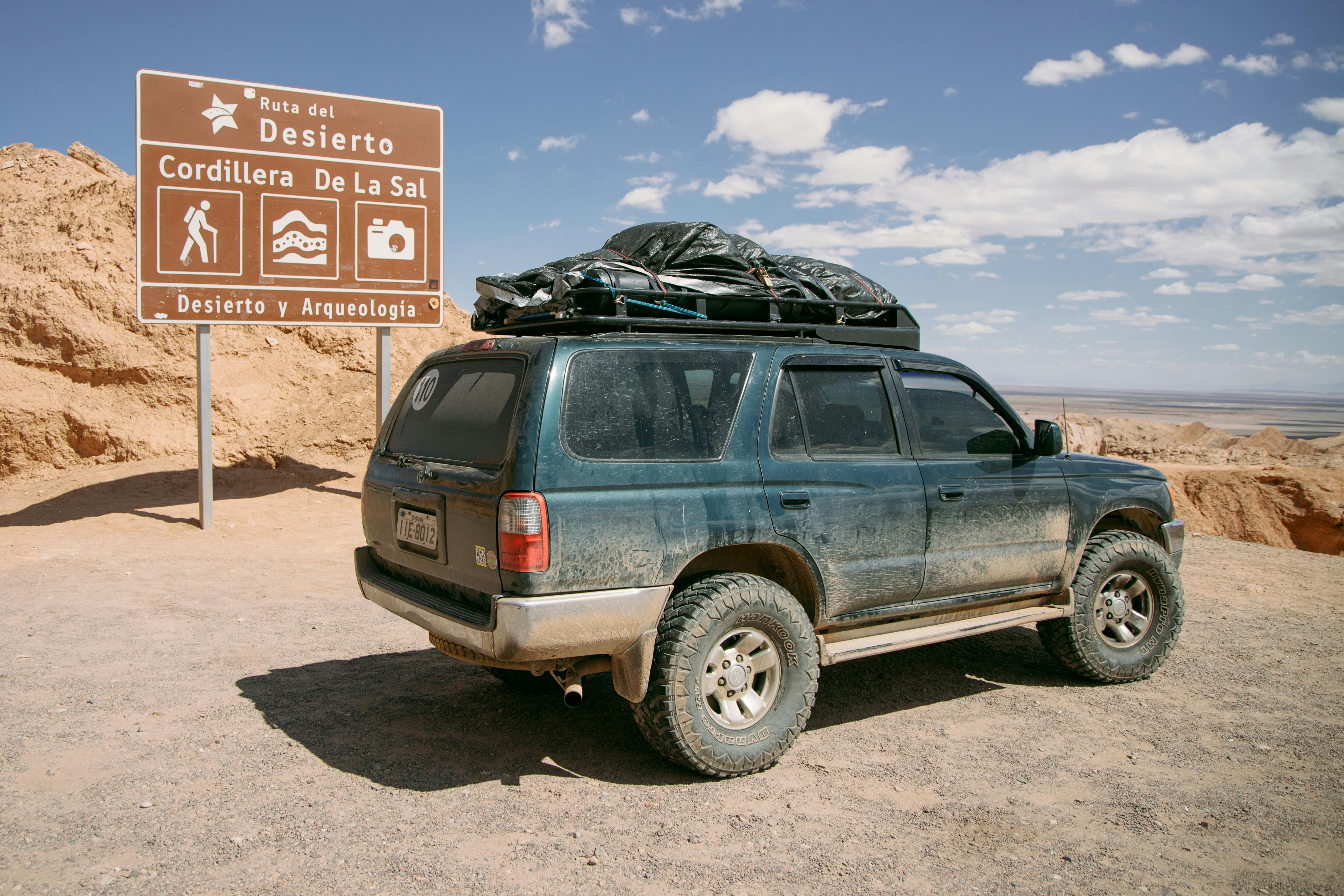 blue green suv car on brown sandy ground