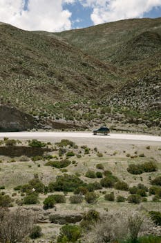 A car travels through a scenic Andean mountain route in Jujuy, Argentina.